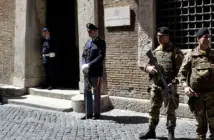 Soldiers and police officers stand guard outside the Italian national anti-mafia services HQ in Rome.